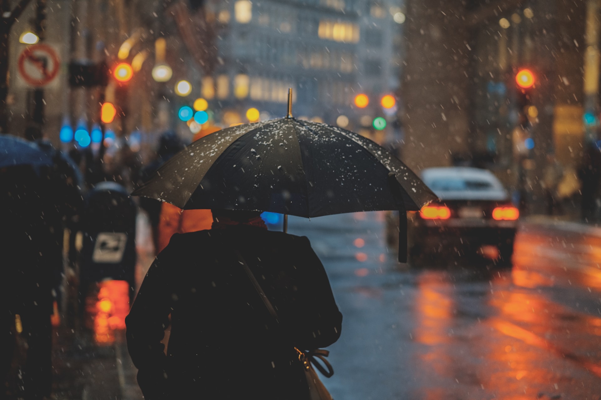 A city scene showing a person walking in the rain