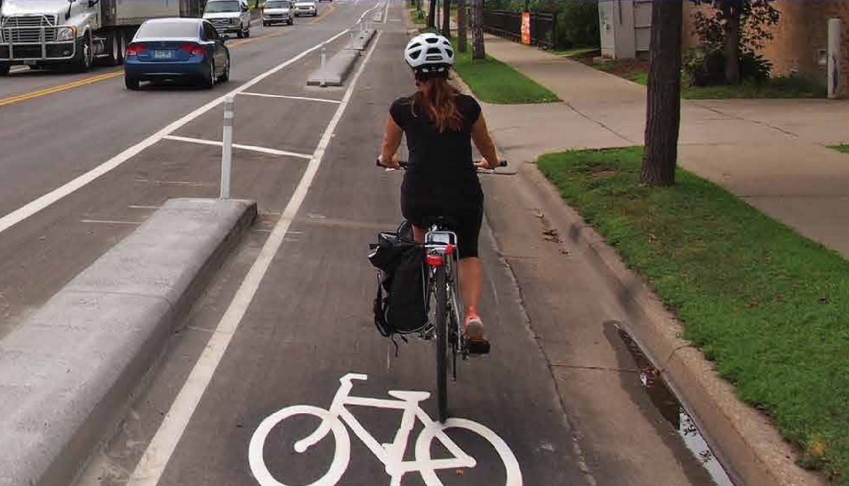 A person rides their bike in a protected bike lane.
