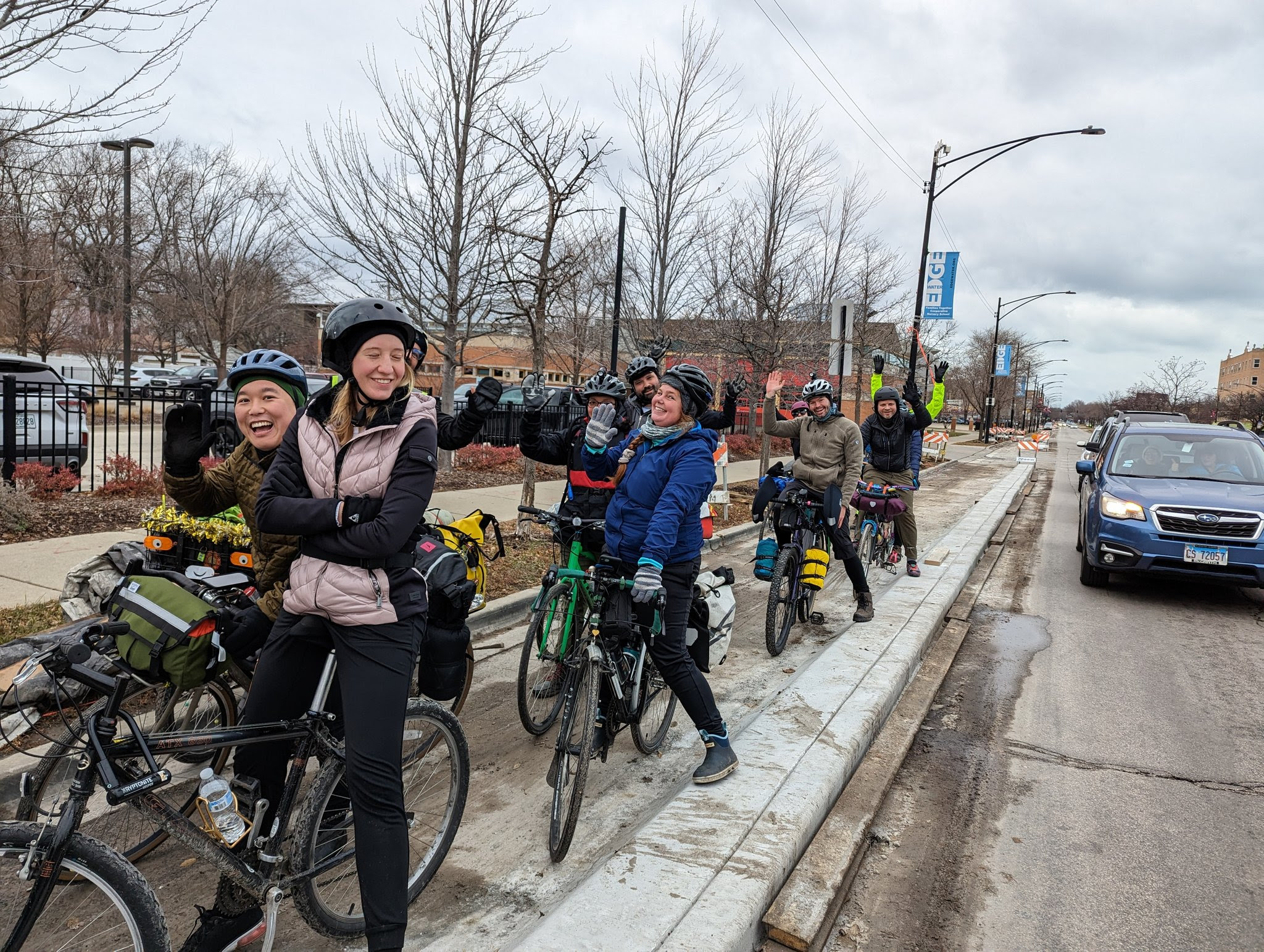 Smiling people riding their bikes in the bike lane on Clark Street.