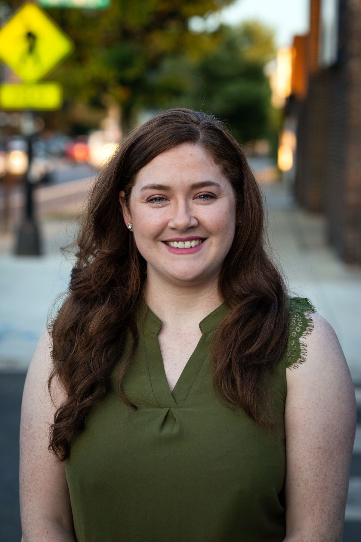 Deirdre O'Connor stands outside and smiles directly into the camera