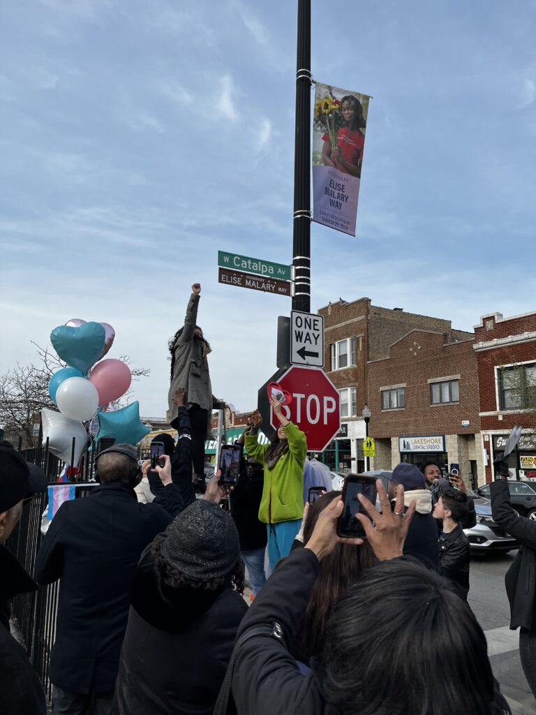 A crowd clapping and cheering as the honorary street sign, Elise Malary Way, is unveiled